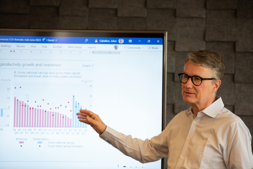 Man pointing at a screen displaying a chart