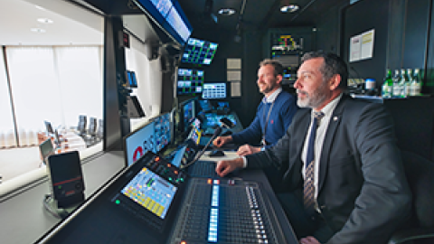 Two people inside a technical sound booth