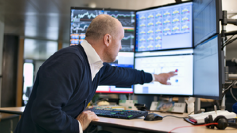 A person pointing at a trading terminal