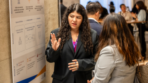 Two people discussing in front of a poster