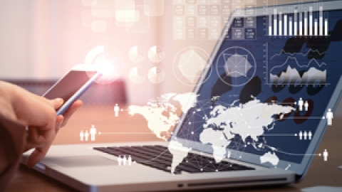 Laptop on the desk with a digital map as background