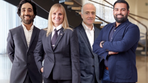 Four employees smiling into the camera