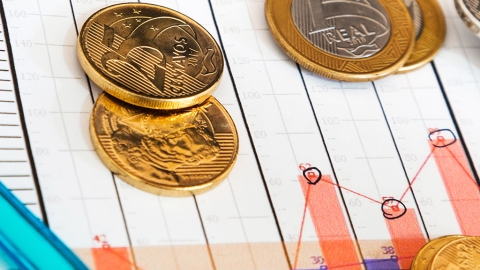 Financial chart with coins and pen