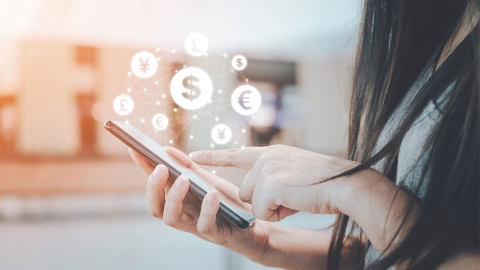 Person using a phone with currency symbols displayed on top of the screen